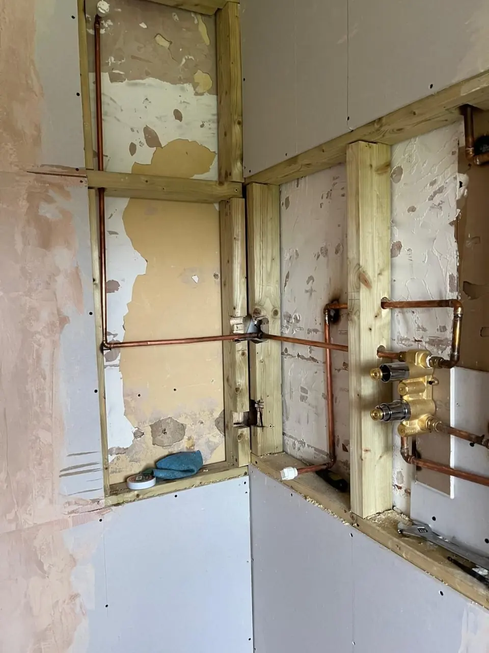 Early progress photograph showing first-fix pipework within the new bathroom wall