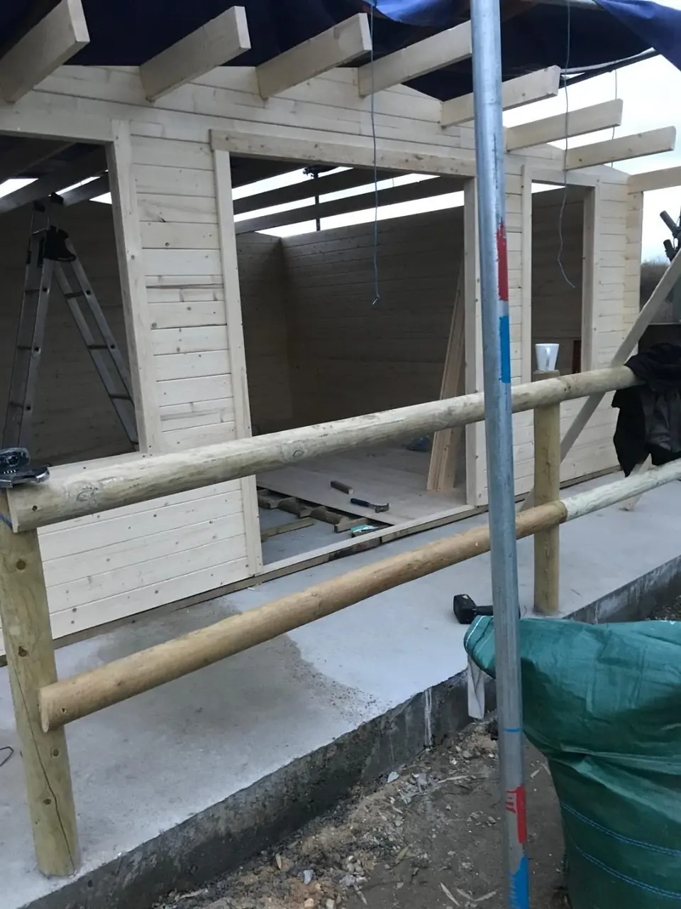 Build-progress photograph showing the initial timber frame taking shape