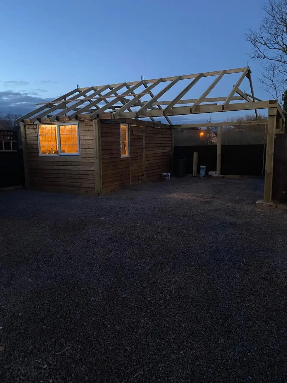 Full timber roof frame visible across the workshop and open car bay