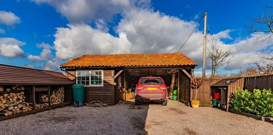 Wide finished-project photograph showing the workshop and open car bay together