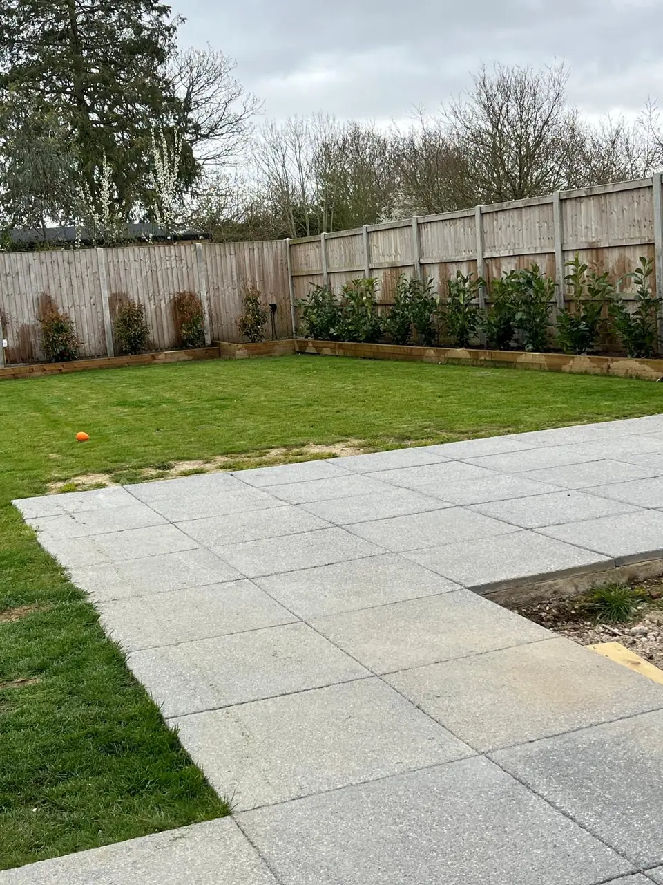 Finished paved seating area beside lawn and planted boundary borders