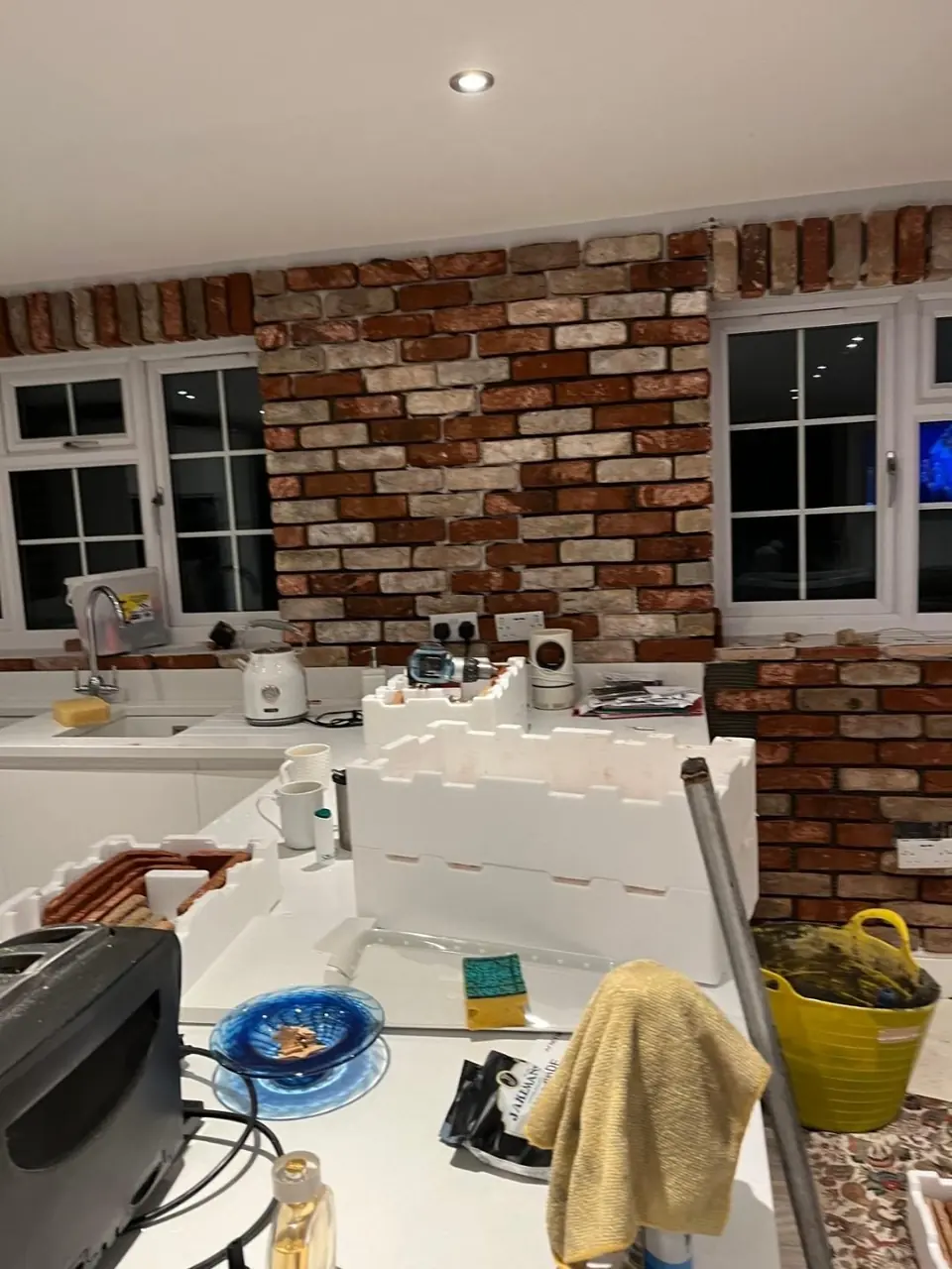 Reclaimed brick slips being laid around the retained windows