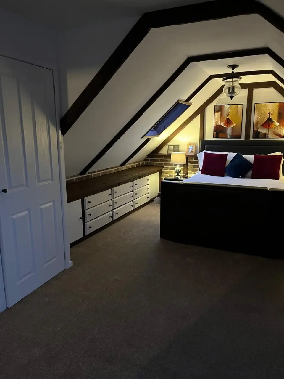Finished-project photograph showing the completed bedroom beneath the roof structure
