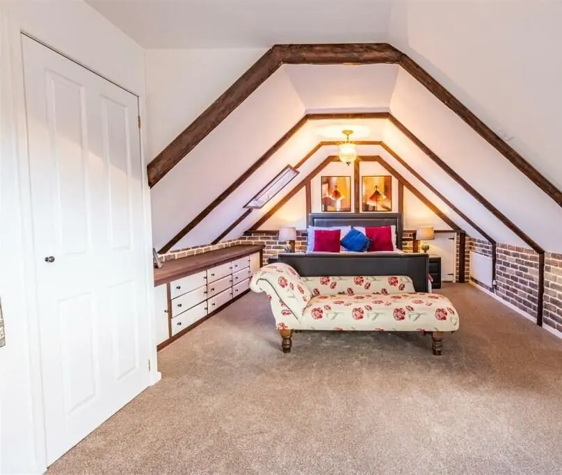 Completed loft bedroom beneath the exposed roof structure