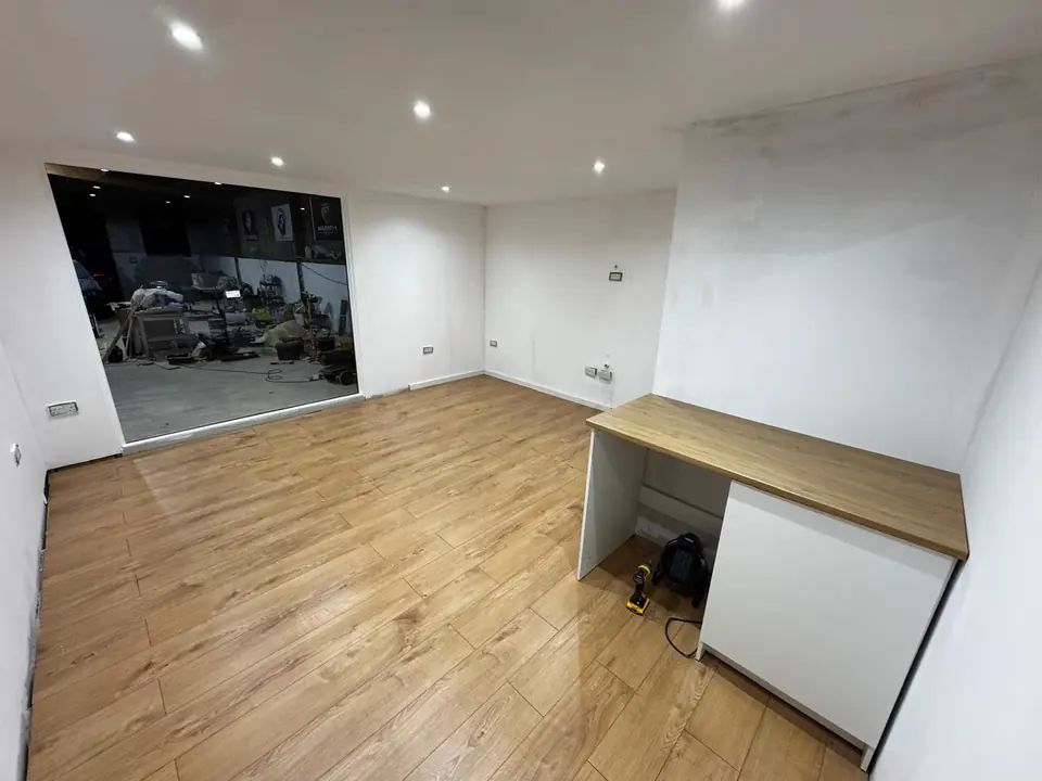 Office pod interior finished with timber-effect flooring and a small worktop