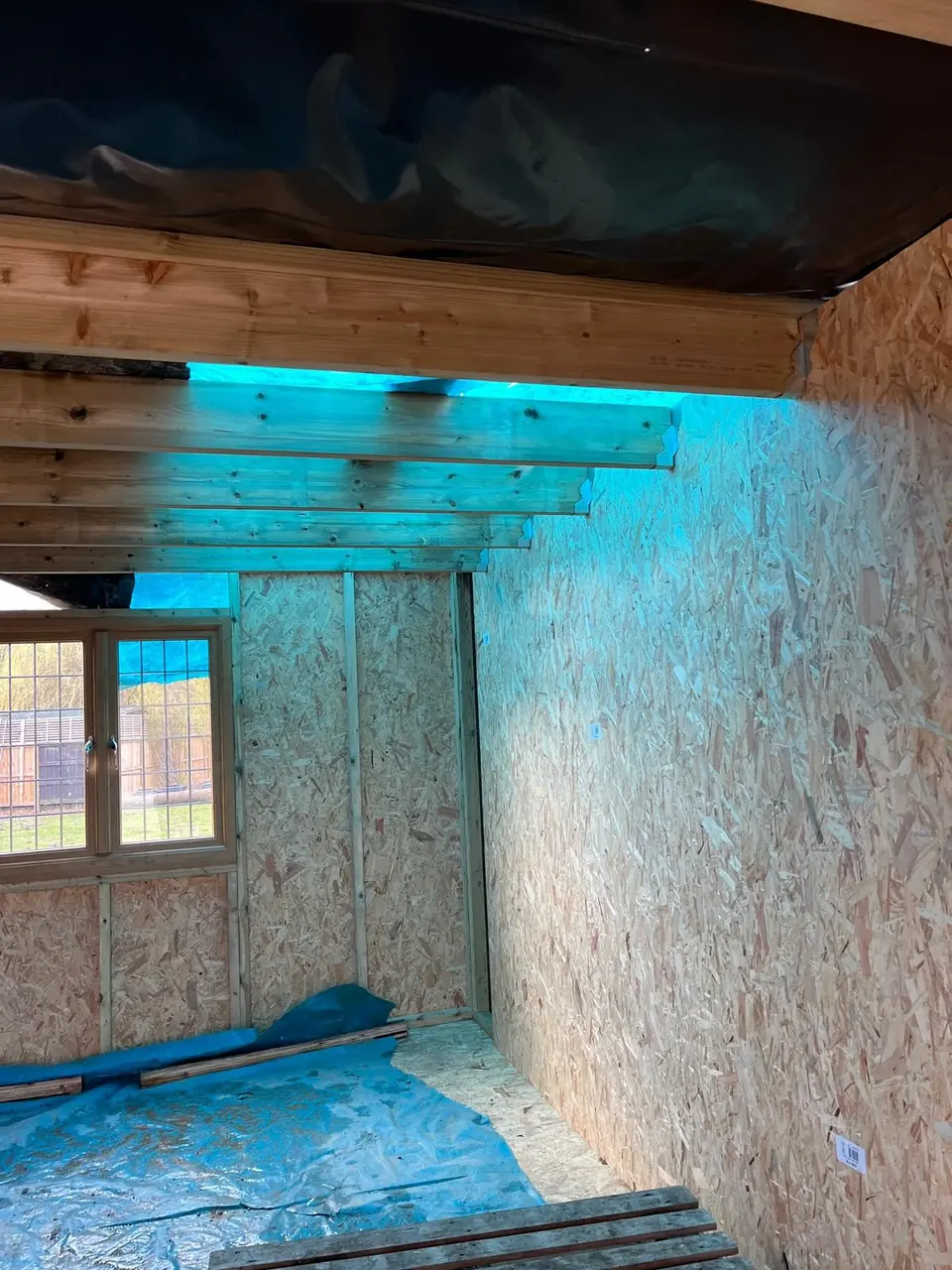 OSB-lined room with exposed timber roof joists during construction